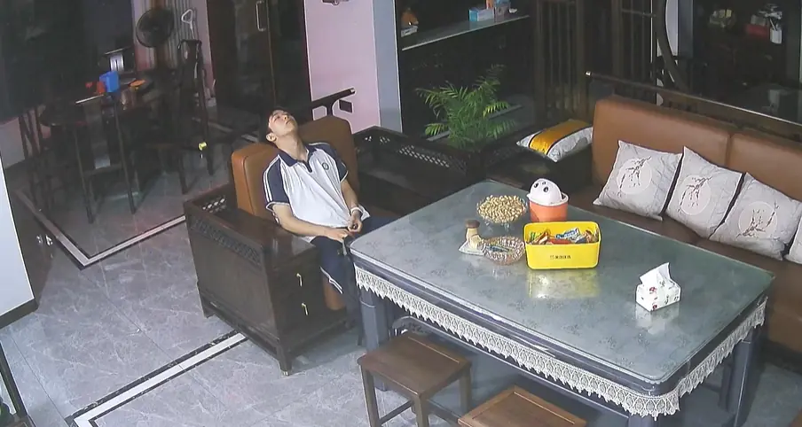 ภาพบรรยากาศของนักเรียนชายที่นั่งเหม่อลอยอยู่กลางห้องนั่งเล่นตอนเวลา 23.00 น. สร้างกระแสถกเถ